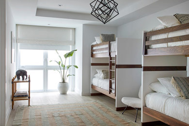 Imagen de dormitorio infantil costero con paredes blancas y suelo beige