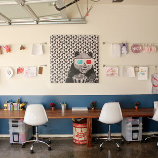Idée de décoration pour une chambre neutre de 4 à 10 ans bohème avec un bureau, béton au sol et un mur multicolore.