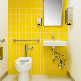 Immagine di una piccola cameretta per bambini da 1 a 3 anni design con pareti gialle, pavimento in laminato e pavimento beige