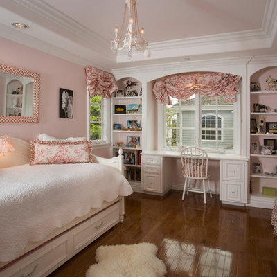 Example of a classic girl medium tone wood floor kids' room design in Orange County with pink walls