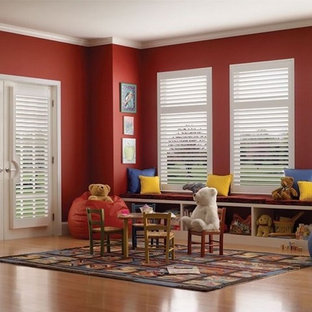 Immagine di una grande cameretta per bambini da 1 a 3 anni classica con pareti rosse, parquet chiaro e pavimento marrone