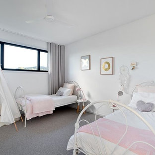 Design ideas for a beach style kids' bedroom for kids 4-10 years old and girls in Gold Coast - Tweed with white walls, carpet and grey floor.