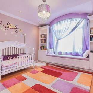 Inspiration pour une grand chambre d'enfant de 1 à 3 ans traditionnelle avec un mur rose et un sol en bois clair.
