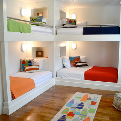 Example of a beach style gender-neutral medium tone wood floor kids' room design in Boston with white walls