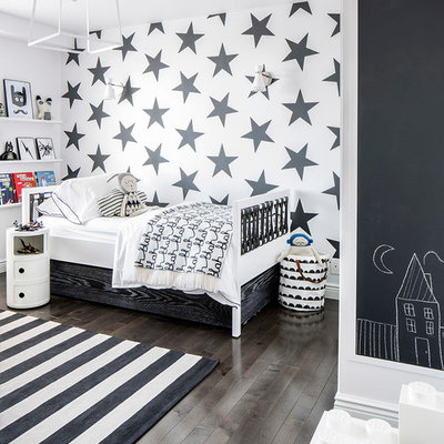 Example of a trendy dark wood floor and brown floor kids' room design in New York with multicolored walls