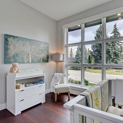 Mid-sized transitional gender-neutral medium tone wood floor kids' room photo in Calgary with gray walls