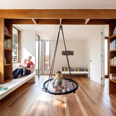 Example of a large trendy boy medium tone wood floor kids' bedroom design in Melbourne with white walls