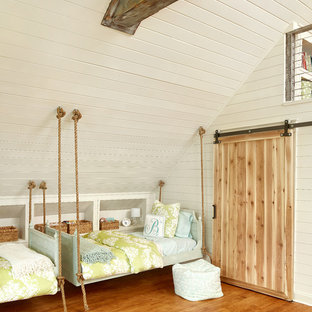 Immagine di una grande cameretta da letto stile marinaro con pareti beige e pavimento in legno massello medio