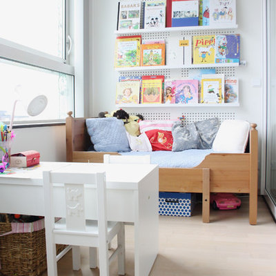 Kids' room - transitional gender-neutral light wood floor kids' room idea in Amsterdam with white walls