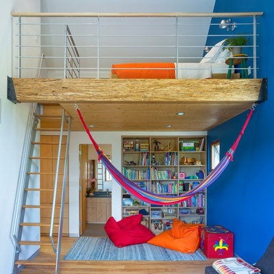 Inspiration for a mid-sized contemporary boy medium tone wood floor and brown floor kids' room remodel in Other with blue walls