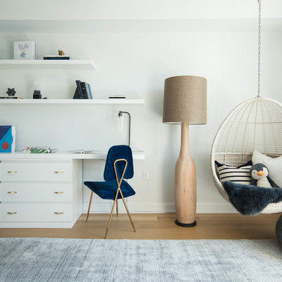 Trendy boy medium tone wood floor and brown floor kids' study room photo in New York with white walls