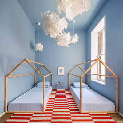 Example of a large trendy gender-neutral light wood floor and brown floor kids' room design in New York with blue walls