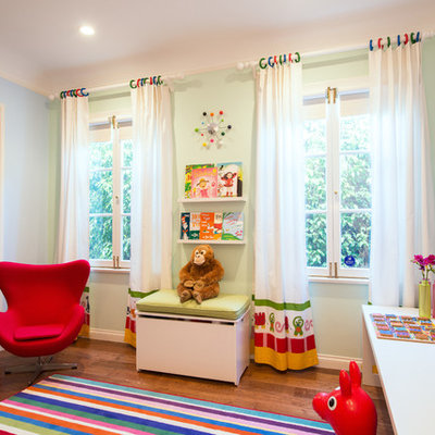 Example of a trendy girl medium tone wood floor playroom design in Los Angeles with green walls