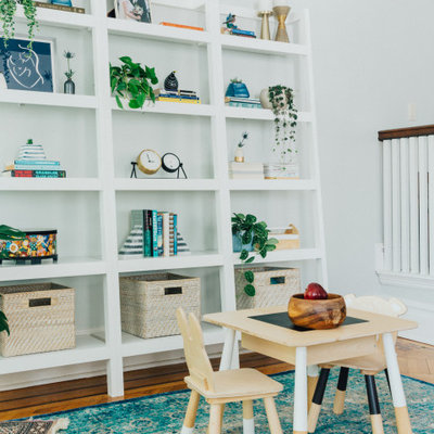 Example of a mid-sized transitional gender-neutral brown floor and dark wood floor kids' room design in New York with white walls