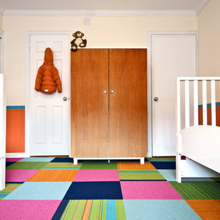 Immagine di una cameretta per bambini da 1 a 3 anni contemporanea con moquette, pavimento multicolore e pareti arancioni