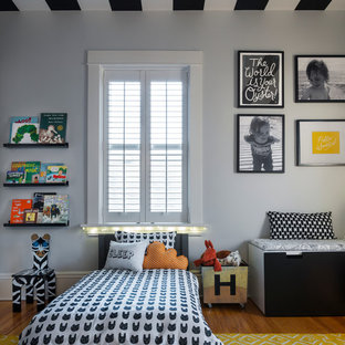 Imagen de dormitorio infantil de 1 a 3 años, clásico renovado, pequeño, con paredes grises, suelo de madera en tonos medios y suelo marrón