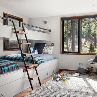 Idee per una grande cameretta per bambini design con pareti bianche, pavimento marrone e pavimento in legno massello medio