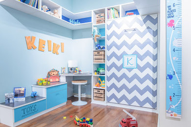 Imagen de dormitorio infantil de 4 a 10 años actual pequeño con paredes azules, suelo de madera en tonos medios y suelo marrón