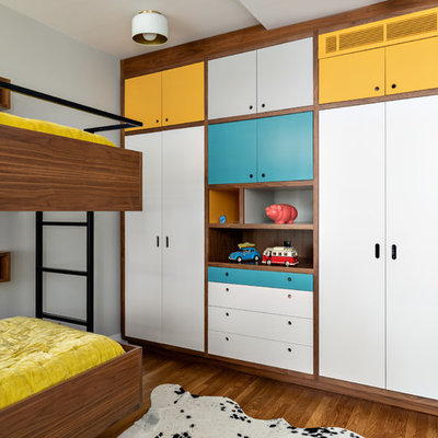 Kids' room - mid-century modern gender-neutral medium tone wood floor kids' room idea in New York with gray walls