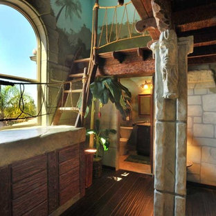 Ispirazione per una grande cameretta per bambini da 4 a 10 anni tropicale con parquet scuro, pareti multicolore e pavimento marrone
