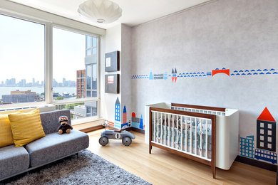 Diseño de dormitorio infantil de 1 a 3 años actual de tamaño medio con paredes grises, suelo de madera en tonos medios y suelo beige