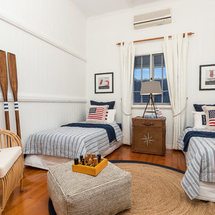 Beach style kids' bedroom in Brisbane with white walls, medium hardwood floors and brown floor for kids 4-10 years old and boys.