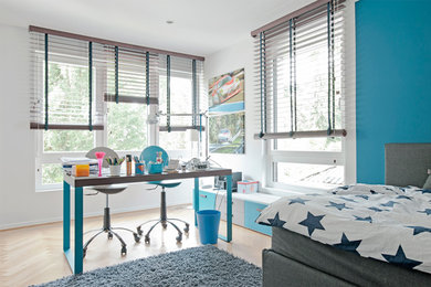 Inspiration för ett mellanstort funkis barnrum kombinerat med skrivbord, med blå väggar, mellanmörkt trägolv och brunt golv