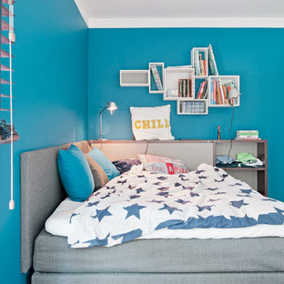 Idee per un'ampia cameretta per bambini design con pareti blu, pavimento in legno massello medio e pavimento marrone