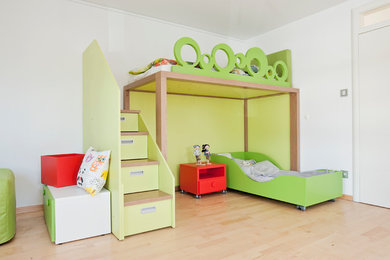 Ispirazione per una cameretta per bambini da 4 a 10 anni design di medie dimensioni con pareti verdi, parquet chiaro e pavimento marrone
