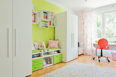 Geräumiges Modernes Mädchenzimmer mit grüner Wandfarbe, Arbeitsecke, hellem Holzboden und braunem Boden in Düsseldorf