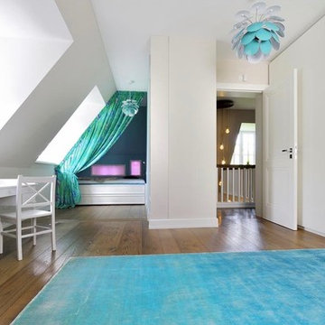 Kinderzimmer mit türkisenem Teppich und weißem Einbauschränken
