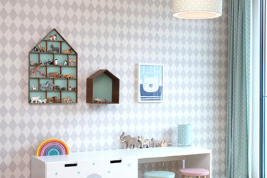 Modelo de dormitorio infantil de 1 a 3 años nórdico de tamaño medio con paredes blancas, suelo de madera en tonos medios y suelo beige