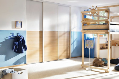 Foto på ett mellanstort funkis pojkrum kombinerat med sovrum och för 4-10-åringar, med vita väggar, heltäckningsmatta och beiget golv