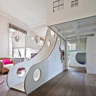 Idee per un'ampia cameretta per bambini da 4 a 10 anni design con pareti bianche e pavimento in legno massello medio