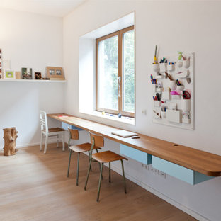 Neutrales Modernes Kinderzimmer mit Arbeitsecke, weißer Wandfarbe, braunem Holzboden und braunem Boden in Sonstige