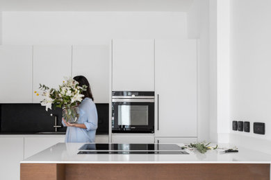 This is an example of a contemporary kitchen in London with flat-panel cabinets.