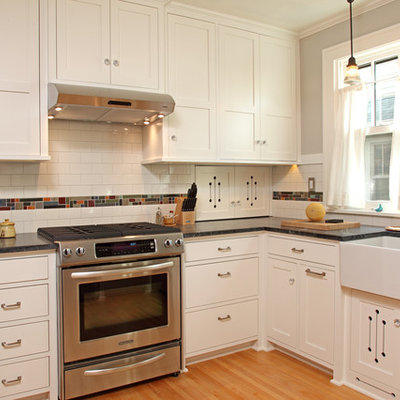 Inspiration for a small craftsman u-shaped light wood floor enclosed kitchen remodel in Minneapolis with a farmhouse sink, white cabinets, multicolored backsplash, stainless steel appliances, recessed-panel cabinets, subway tile backsplash, no island and soapstone countertops