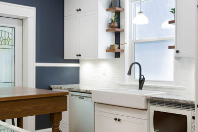 Inspiration for a small timeless galley medium tone wood floor and brown floor kitchen pantry remodel in Other with a farmhouse sink, shaker cabinets, white cabinets, granite countertops, white backsplash, subway tile backsplash, stainless steel appliances, a peninsula and gray countertops