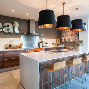 Contemporary galley kitchen in West Midlands with a built-in sink, flat-panel cabinets, dark wood cabinets, coloured appliances, an island and grey floors.