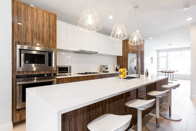 Inspiration for a medium sized contemporary kitchen/diner in Edmonton with flat-panel cabinets, granite worktops, white splashback, stainless steel appliances, light hardwood flooring, an island, a double-bowl sink, white cabinets and beige floors.