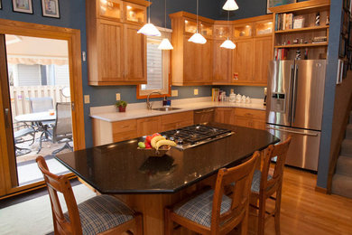 Inspiration for a mid-sized craftsman l-shaped light wood floor eat-in kitchen remodel in Minneapolis with a single-bowl sink, recessed-panel cabinets, medium tone wood cabinets, quartz countertops, stainless steel appliances and an island