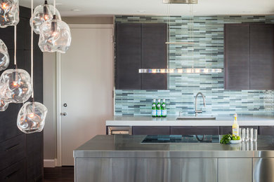 Open concept kitchen - mid-sized contemporary l-shaped dark wood floor open concept kitchen idea in San Francisco with an undermount sink, flat-panel cabinets, dark wood cabinets, quartz countertops, blue backsplash, glass tile backsplash, paneled appliances and an island
