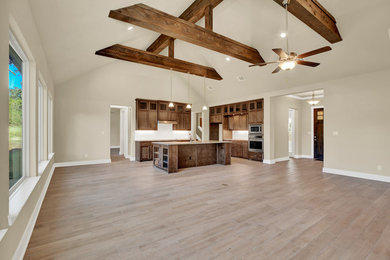 Inspiration for a large timeless u-shaped light wood floor and beige floor open concept kitchen remodel in Austin with recessed-panel cabinets, medium tone wood cabinets, an island, a farmhouse sink, granite countertops, white backsplash, subway tile backsplash, stainless steel appliances and gray countertops