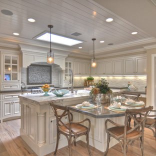 Coastal kitchen designs - Inspiration for a coastal kitchen remodel in Los Angeles with recessed-panel cabinets, white cabinets and beige backsplash