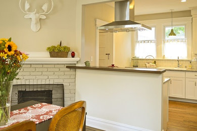 Kitchen - mid-sized contemporary medium tone wood floor kitchen idea in New York with an undermount sink, shaker cabinets, white cabinets, granite countertops, white backsplash, subway tile backsplash and stainless steel appliances