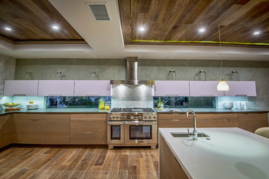 Inspiration for a large contemporary u-shaped medium tone wood floor kitchen remodel in Los Angeles with a farmhouse sink, flat-panel cabinets, brown cabinets, quartz countertops, gray backsplash, stone slab backsplash, stainless steel appliances and an island