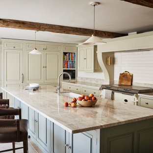 Photo of a classic kitchen in Wiltshire with a belfast sink, beaded cabinets, beige cabinets, white splashback, metro tiled splashback, an island, beige floors and beige worktops.