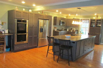 Mid-sized cottage l-shaped light wood floor eat-in kitchen photo in Providence with a drop-in sink, shaker cabinets, gray cabinets, laminate countertops, green backsplash, stainless steel appliances and an island