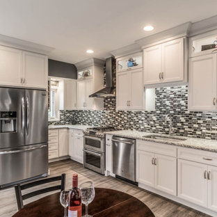 Small traditional kitchen pictures - Small elegant single-wall vinyl floor and brown floor kitchen photo in Philadelphia with a drop-in sink, flat-panel cabinets, white cabinets, granite countertops, multicolored backsplash, ceramic backsplash, stainless steel appliances, no island and gray countertops