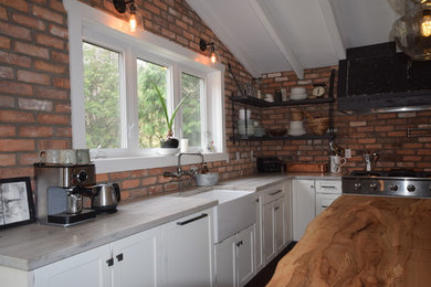 Example of a mid-sized cottage u-shaped light wood floor and brown floor open concept kitchen design in Toronto with a farmhouse sink, shaker cabinets, soapstone countertops, brick backsplash, stainless steel appliances, an island, brown backsplash and white cabinets
